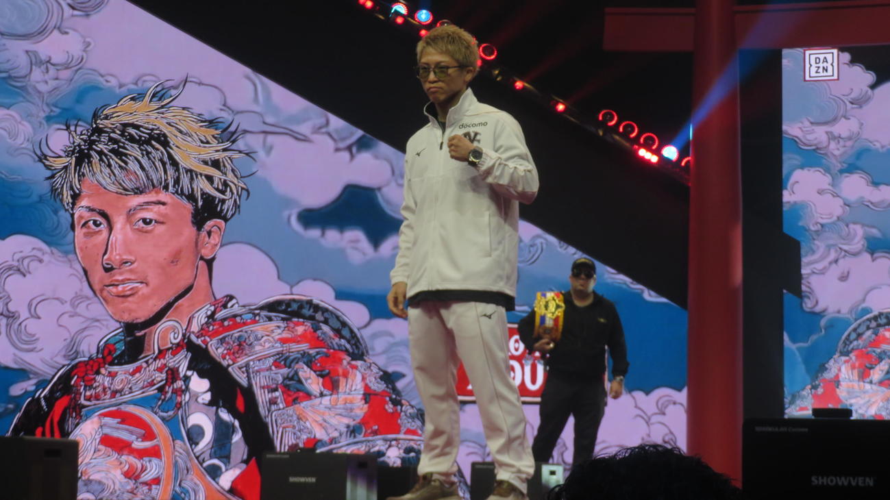 井上尚弥の大型イラストがビジョンに登場する中、到着イベントでポーズする井上尚弥