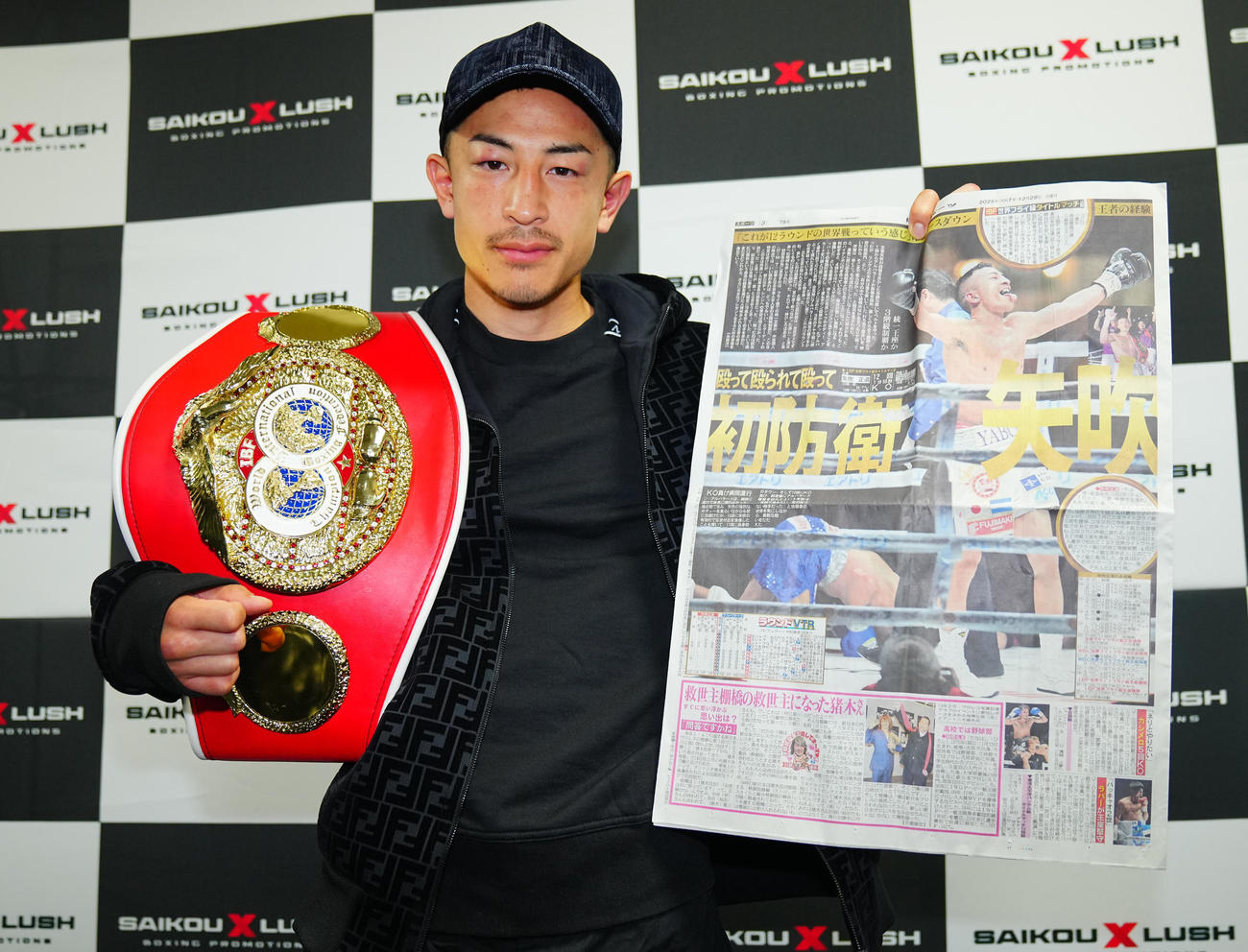 初防衛戦から一夜明け日刊スポーツを手に写真に納まるIBF世界フライ級王者の矢吹（撮影・垰建太）