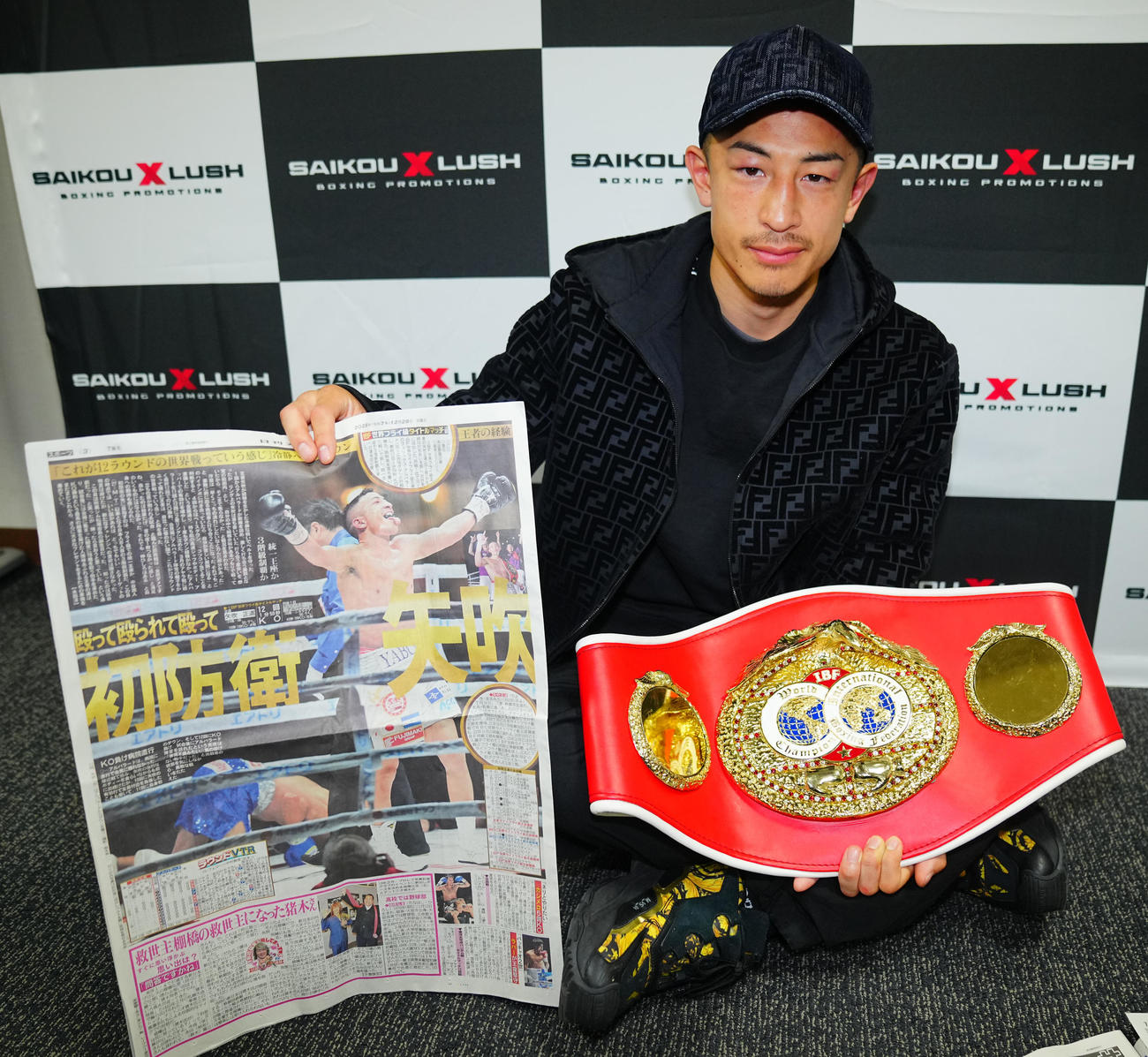初防衛戦から一夜明け日刊スポーツを手に写真に納まるIBF世界フライ級王者の矢吹（撮影・垰建太）