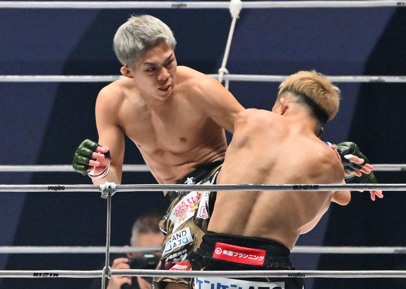 1回、秋元強真（左）は新井すぐるに蹴りを見舞う（撮影・滝沢徹郎）
