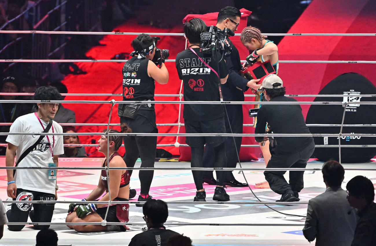 RENA（左）に勝利し防衛に成功した伊沢星花は榊原信行CEOからベルトを受け取る（撮影・滝沢徹郎）