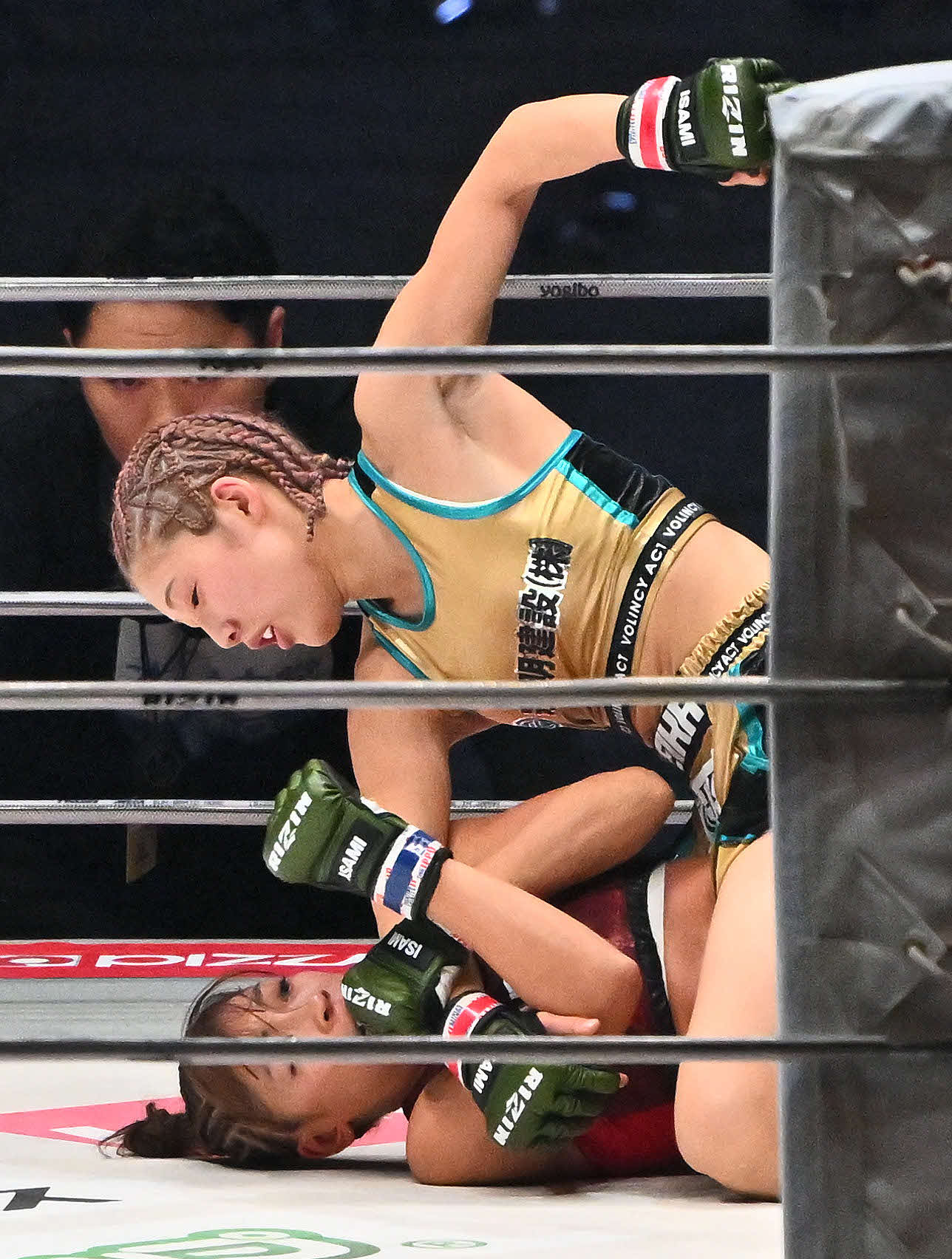 1回、伊沢星花（上）はRENAにパンチを打ち込む（撮影・滝沢徹郎）