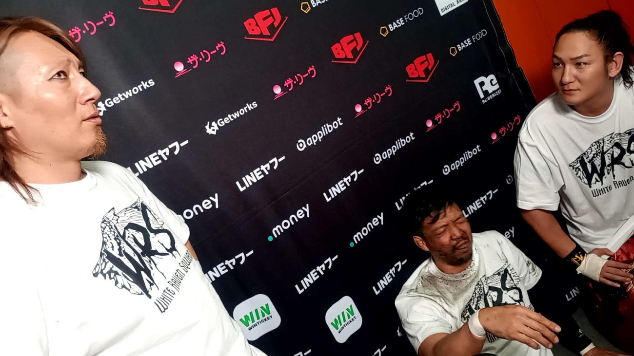 毒霧で顔が真っ黒になったKENTA（中央）はHAYATA（左）と組んでGHCタッグ王座に挑戦することになった