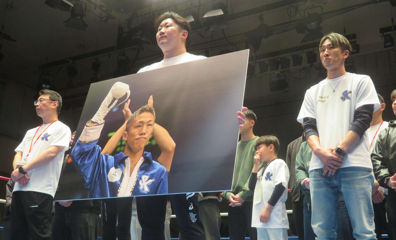 神足茂利さんの追悼引退式で写真を持つ兄神足昌治さん（中央）。左橋は所属ジムの村野健会長