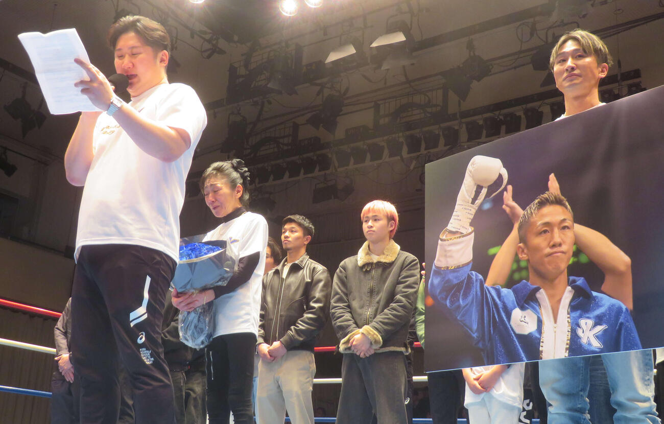 神足茂利さんの追悼引退式であいさつする兄昌治さん（左橋）。中谷潤人（左から3番目）らジムメートもリングで追悼
