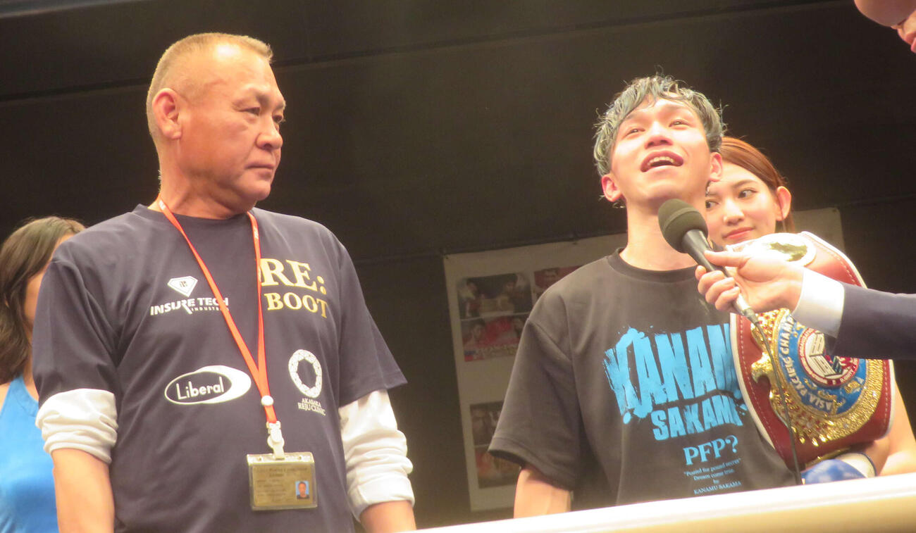 セコンドに入った父憲一トレーナー（左）と勝利者インタビューを受けたWBOアジア・パシフィック・フライ級王者富岡浩介