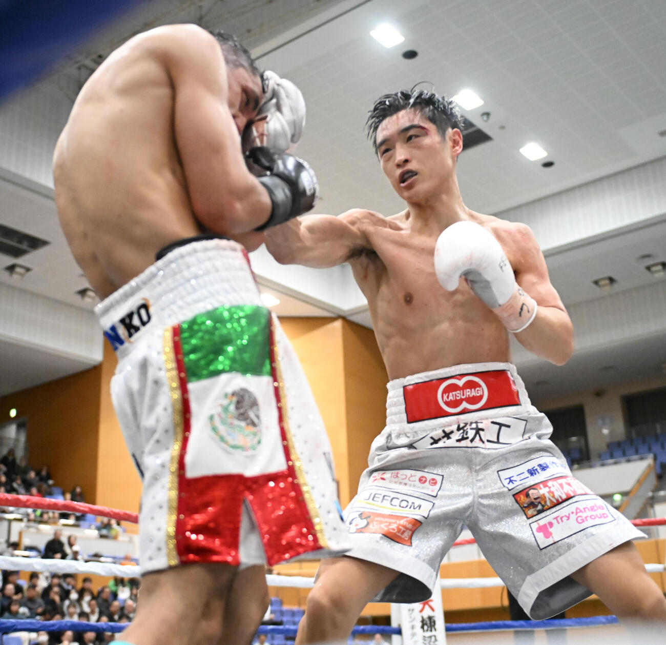 6回、バスケス（左）に右フックを浴びせる西田（撮影・和賀正仁）