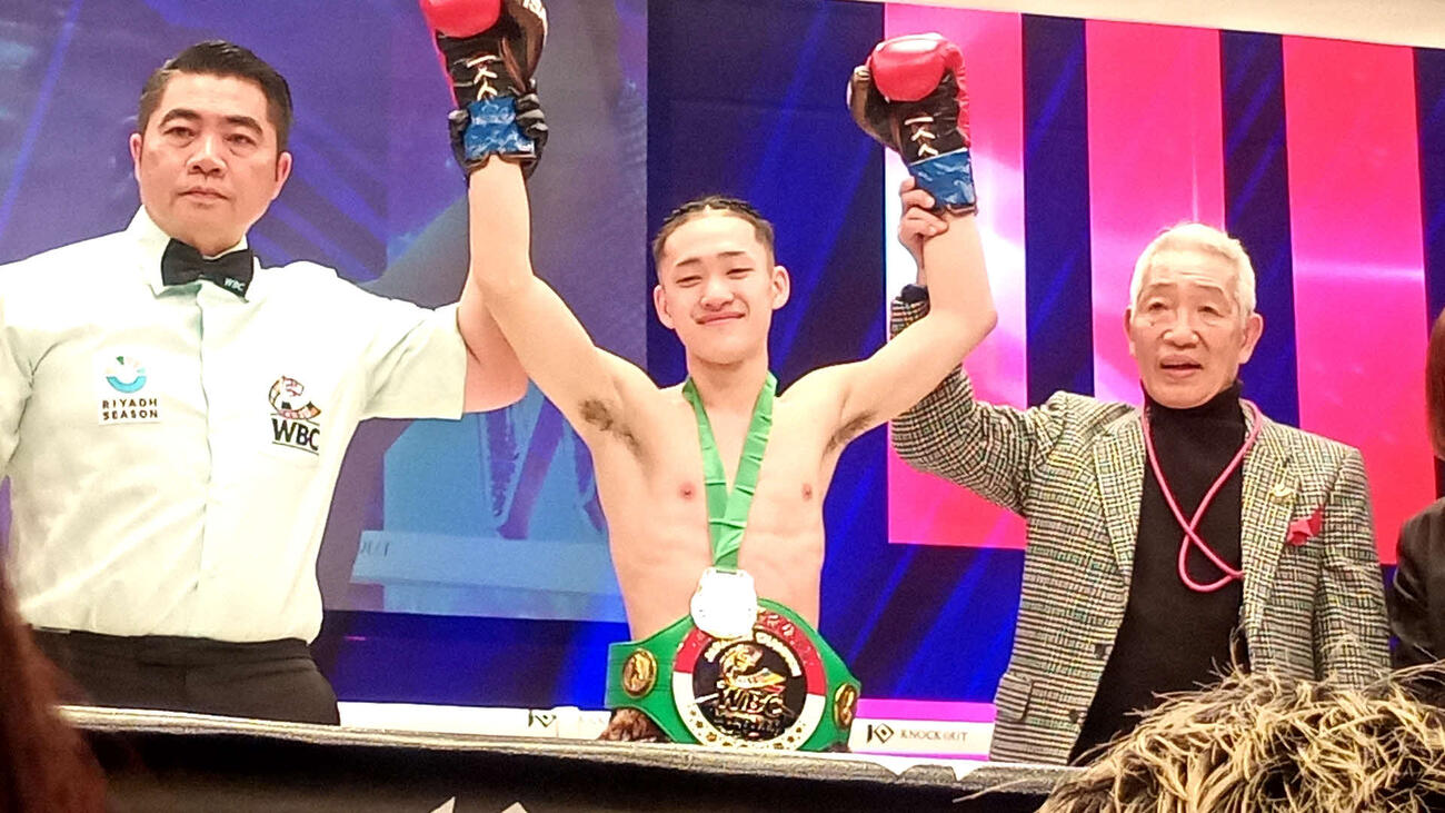 “キックの神様”藤原敏男さん（右）からベルトを巻いてもらった渡部蕾（中央）