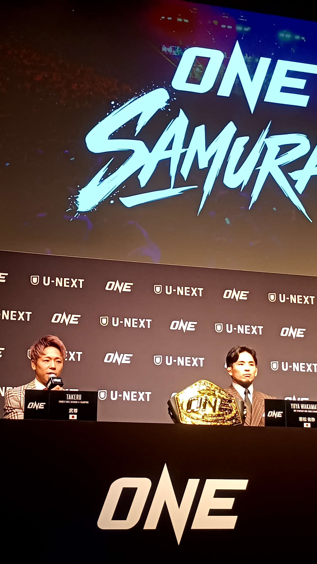ONE SAMURAIのロゴの前で話す武尊（左）と若松佑弥