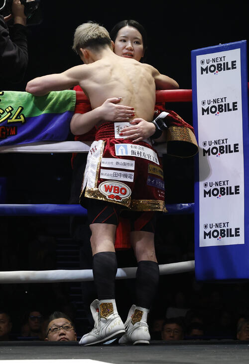 試合前、トレーナーの真成美夫人（右）とハグする飯村（撮影・山本朝陽）