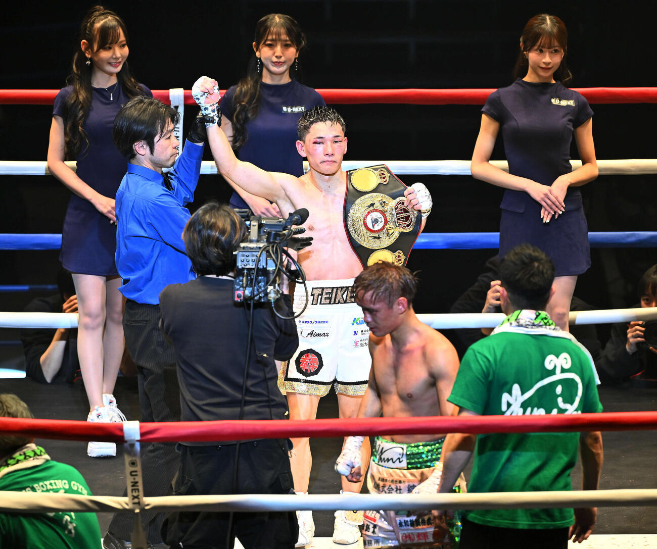 防衛に成功しベルトを肩にかけ勝ち名乗りを受ける松本。手前は高田（撮影・滝沢徹郎）