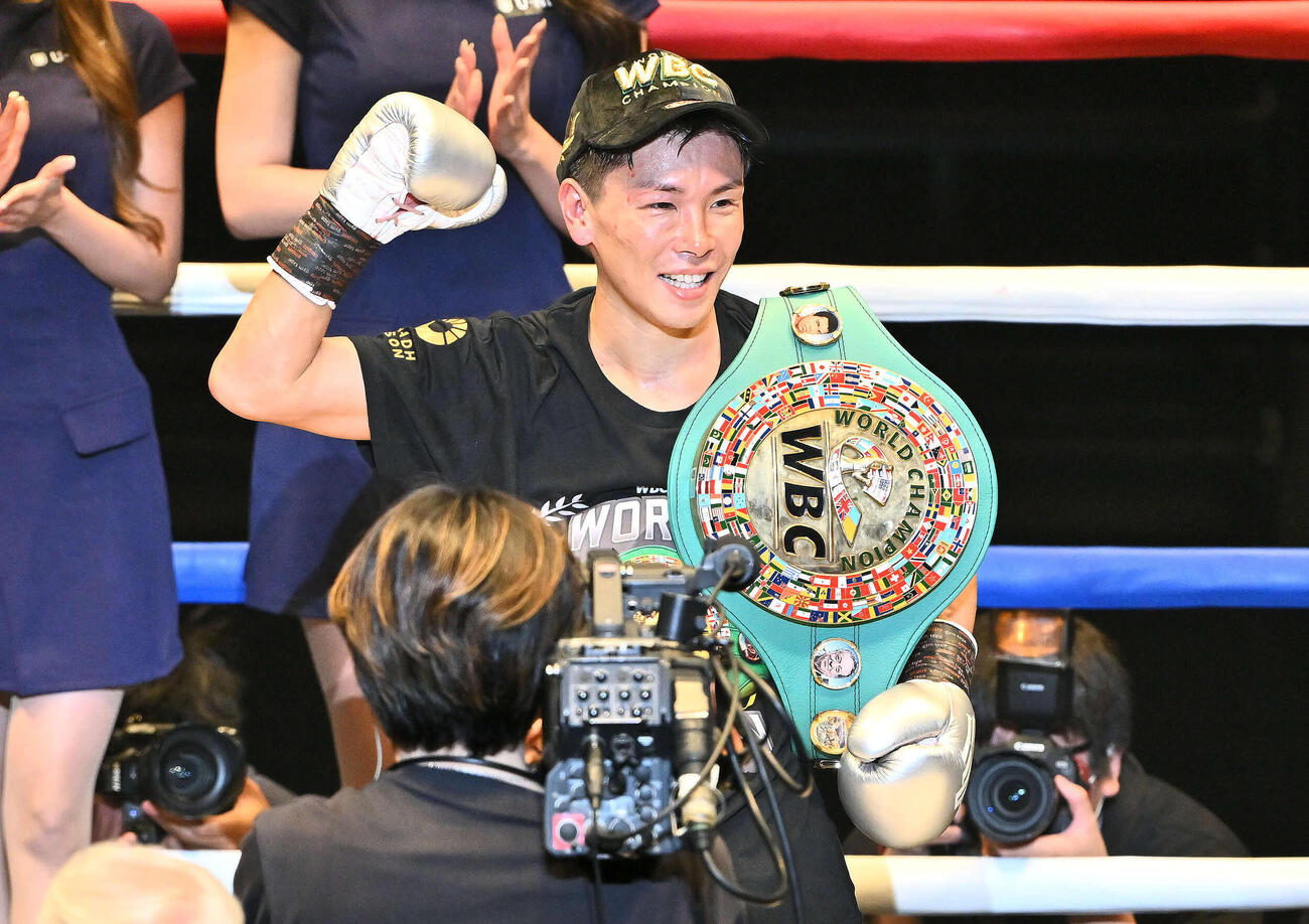 負傷判定勝ちで新チャンピオンとなりベルトを肩に笑顔の岩田（撮影・滝沢徹郎）