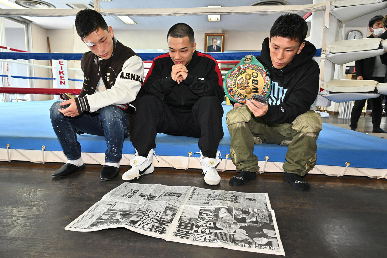 一夜明け会見で試合を報じる日刊スポーツ見る、左から松本、増田、岩田（撮影・滝沢徹郎）
