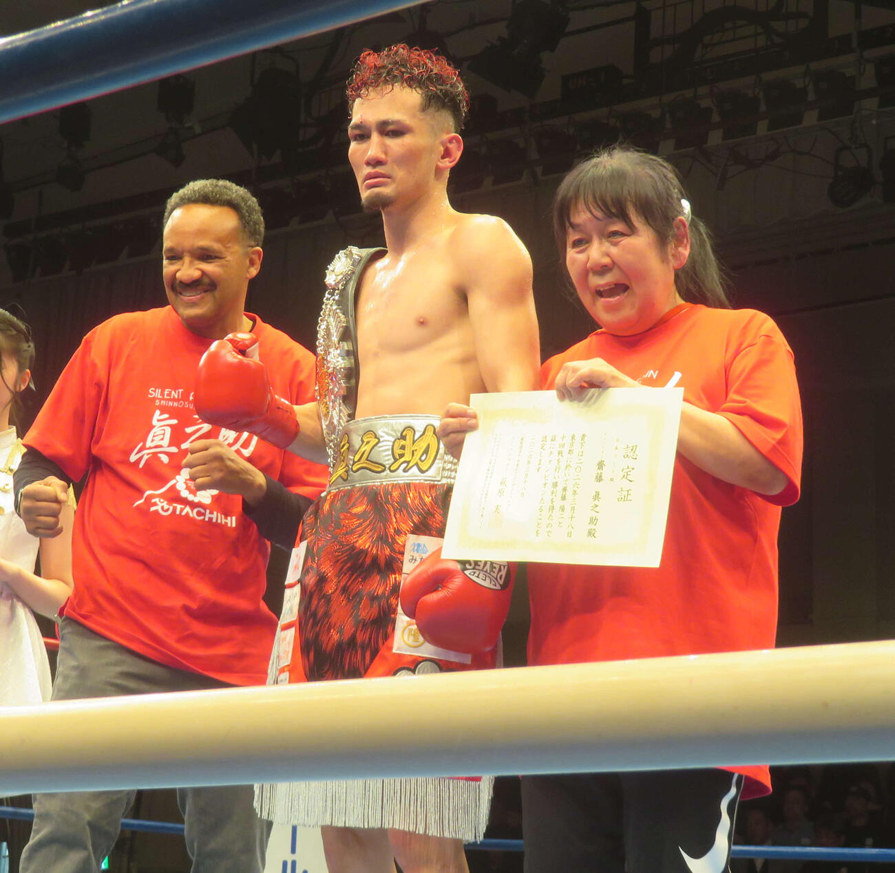 日本ライト級王座を獲得した斎藤真之助（中央）。左端はジムOBのリック吉村氏、右端は所属ジムの石川久美子会長