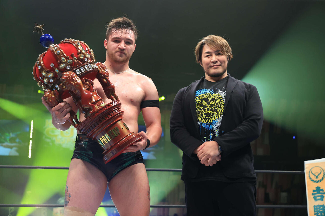 棚橋弘至社長（右）からトロフィーを受け取ったカラム・ニューマン（C）新日本プロレス