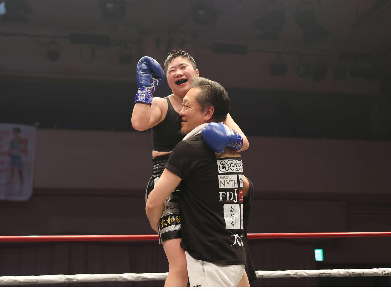 10回を終え山下会長（下）に抱きかかえられ拳を上げる山中（撮影・増田悦実）