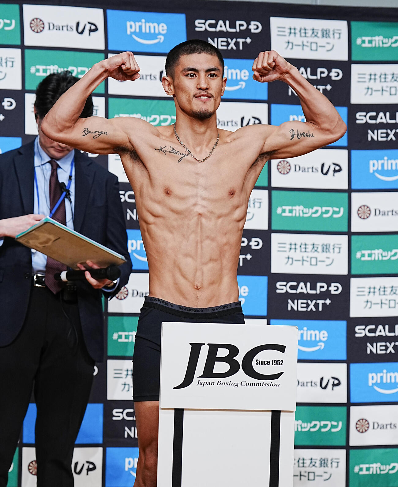 WBC世界バンタム級10回戦の計量をパスしポーズを決める秋次（撮影・小沢裕）