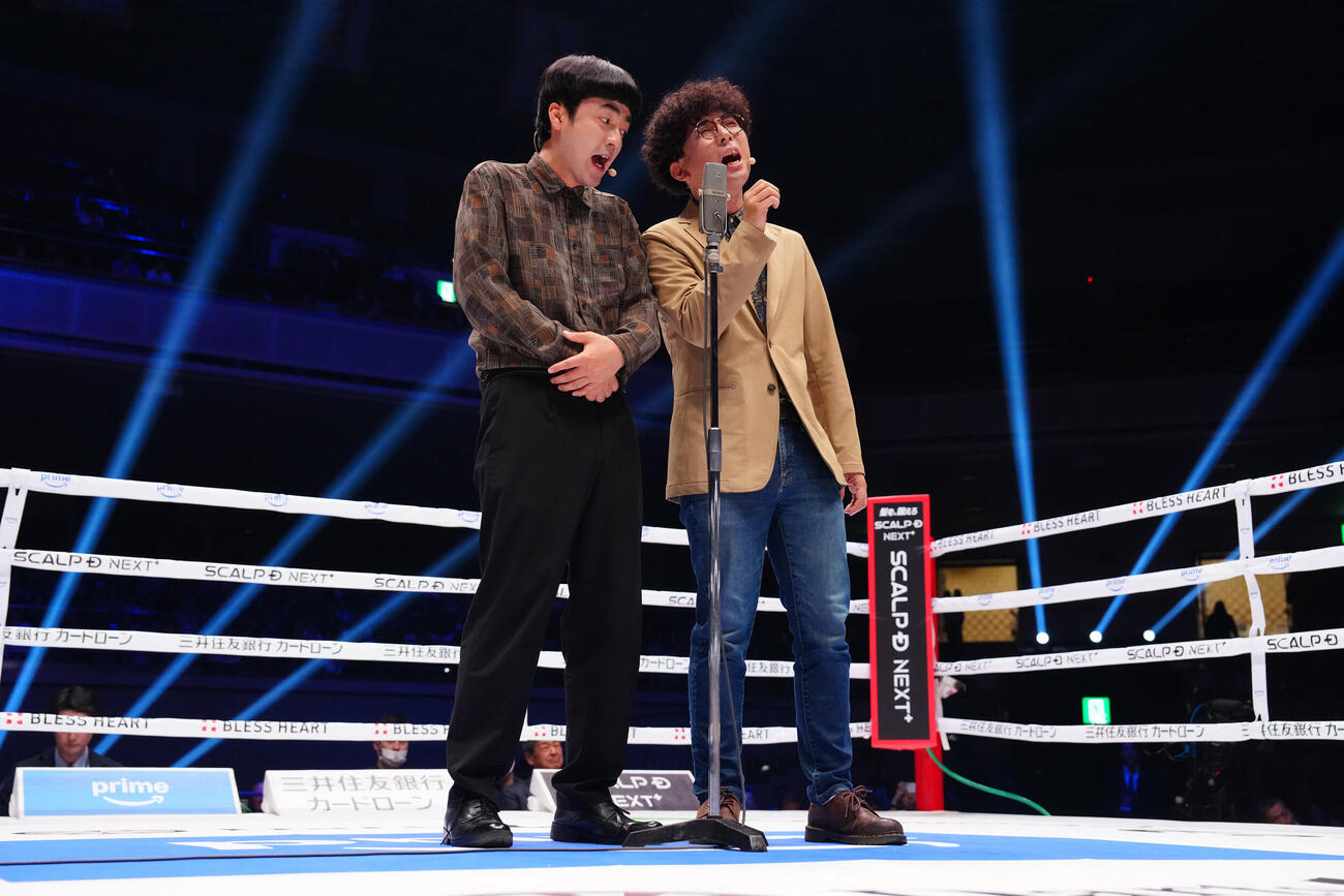 試合前のリング上で漫才を披露したたくろうの赤木裕（左）ときむらバンド（撮影・鈴木みどり）