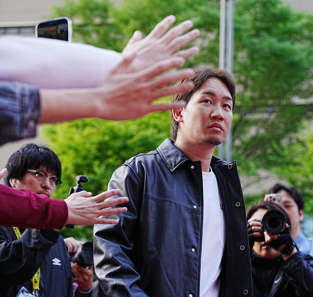 「超緊急記者会見」でファンの声援を受けながら入場する朝倉（撮影・小沢裕）