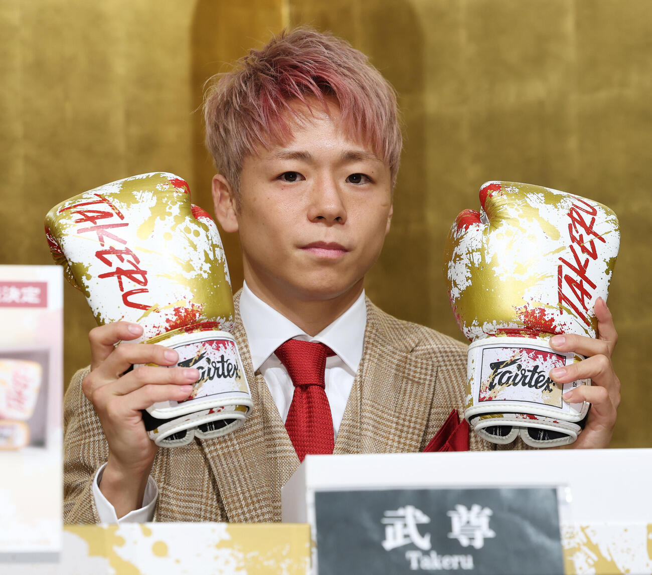 引退記者会見で引退記念グローブを紹介する武尊（撮影・宮地輝）