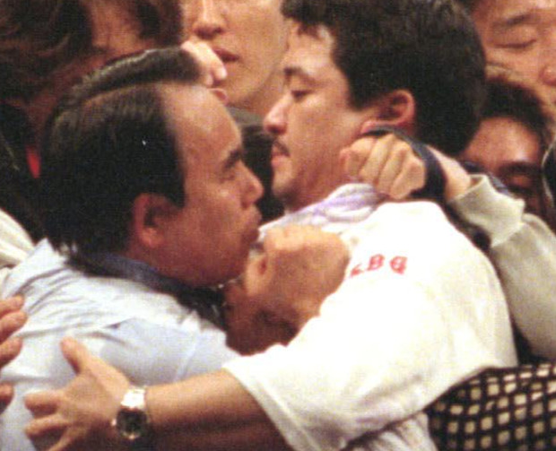 1998年4月29日、WBA世界ジュニアバンタム級タイトルマッチ　飯田覚士対井岡弘樹　判定に不服のファンがリング内に乱入し森田健レフェリー（左）に詰め寄る
