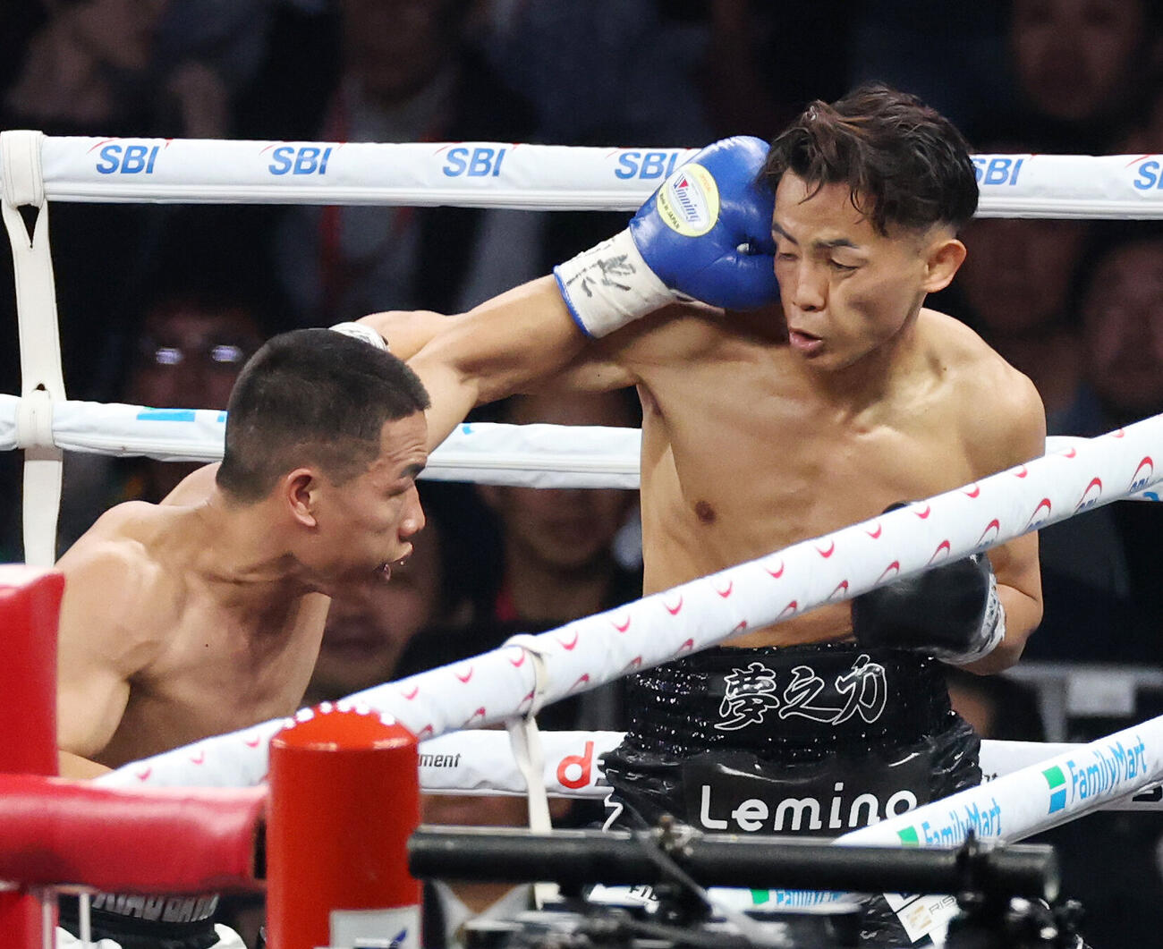 スーパーバンタム級8回戦　3回、ワン・デカン（左）パンチを浴びる武居由樹（撮影・宮地輝）
