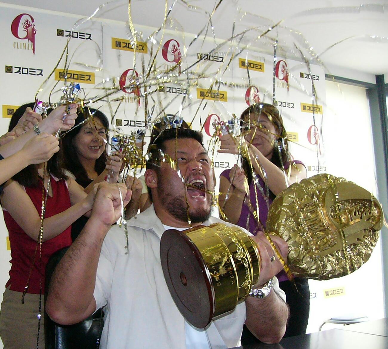 2003年8月、天山広吉は女性社員にお祝いのクラッカーを受けガッツポーズ