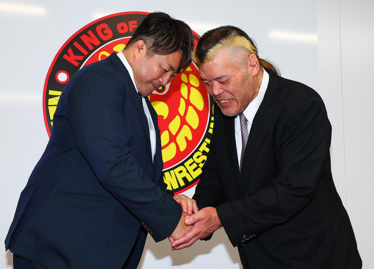 引退会見で棚橋弘至社長（左）と握手する天山広吉（撮影・野上伸悟）