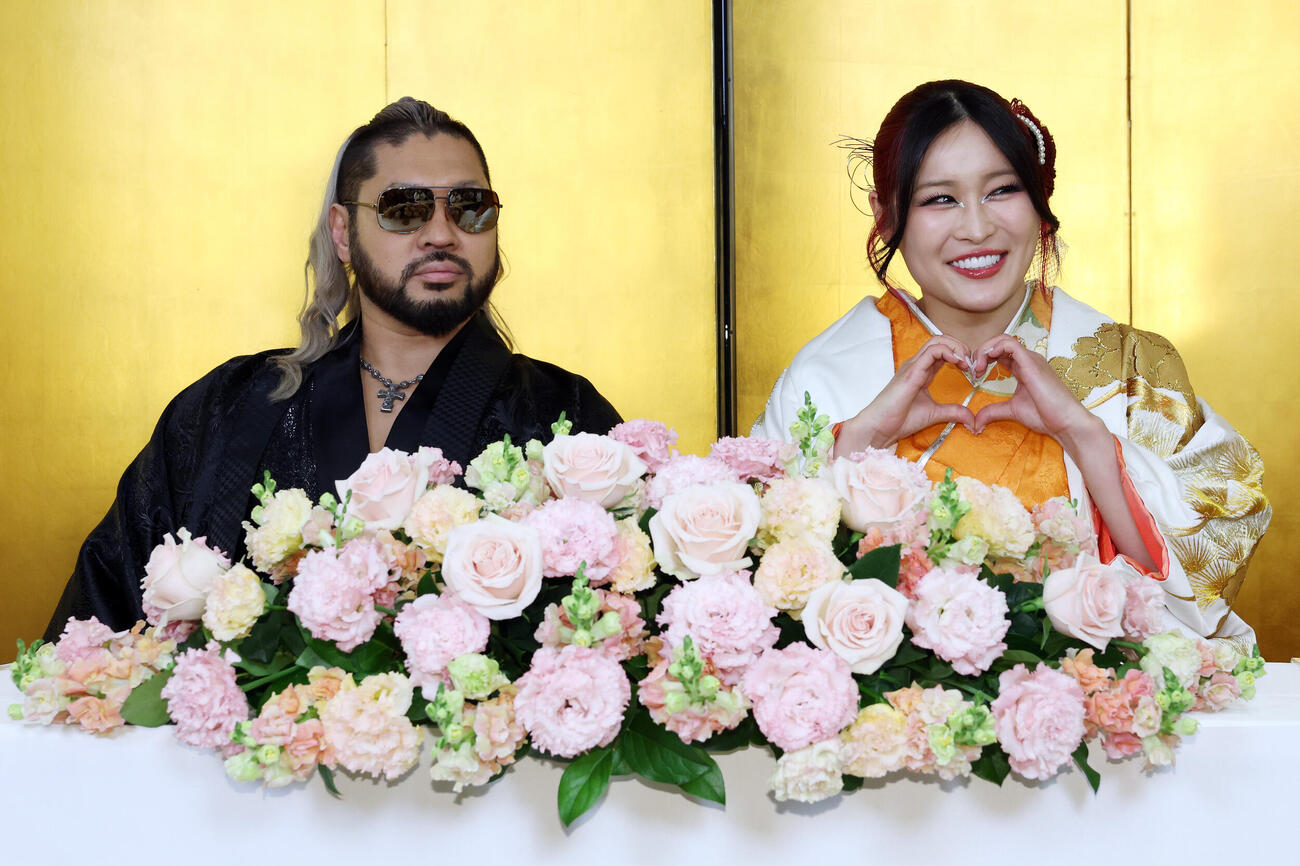 結婚発表会見に登壇したNARAKU（左）と笑顔でハートを作るイヨ・スカイ（撮影・宮地輝）