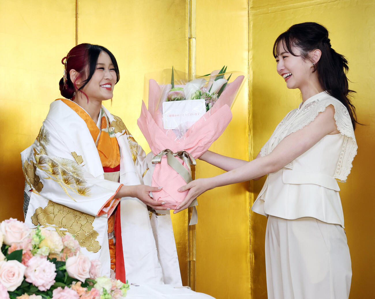 結婚を発表し、まつきりな（右）から花束を受け取るイヨ・スカイ（撮影・宮地輝）