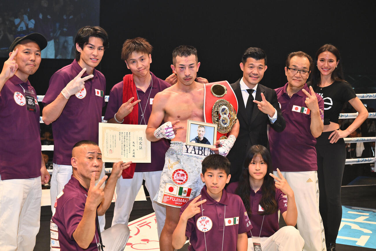 IBF世界フライ級タイトルマッチ　矢吹正道対レネ・カリスト　防衛に成功した矢吹正道（後列中央）はチームと記念撮影する。後列右から3人目は亀田興毅ファウンダー（撮影・滝沢徹郎）