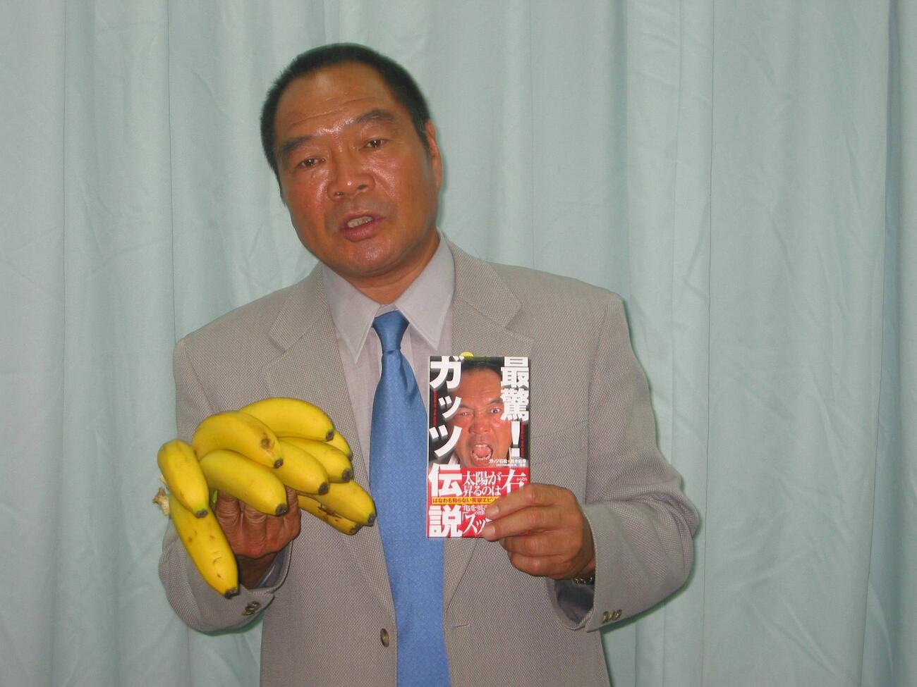 ガッツ石松「最驚！　ガッツ伝説」出版記念サイン会　「大好物のバナナ？　右手に持ち単行本「最驚！　ガッツ伝説」をPRするガッツ石松さん＝2004年8月