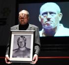 ルスカ氏の遺影を手に１０カウントゴングで追悼する藤原（撮影・下田雄一）