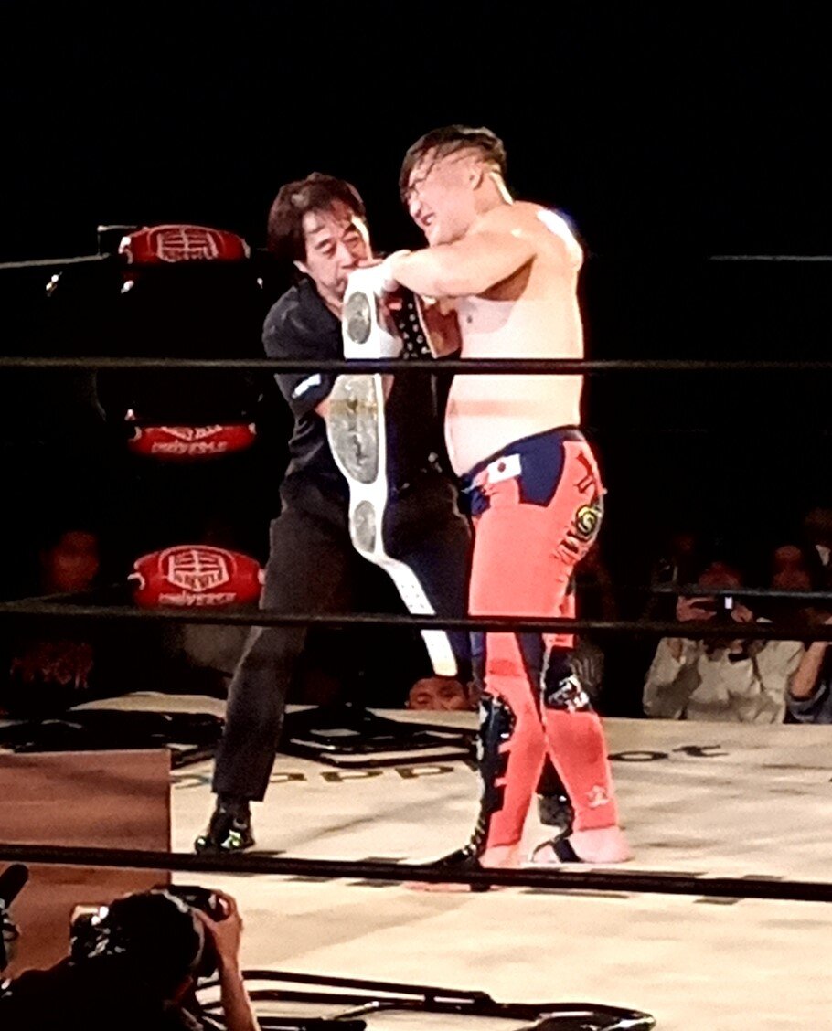 西永レフェリーに支えられて何とか立ち上がった佐藤光留
