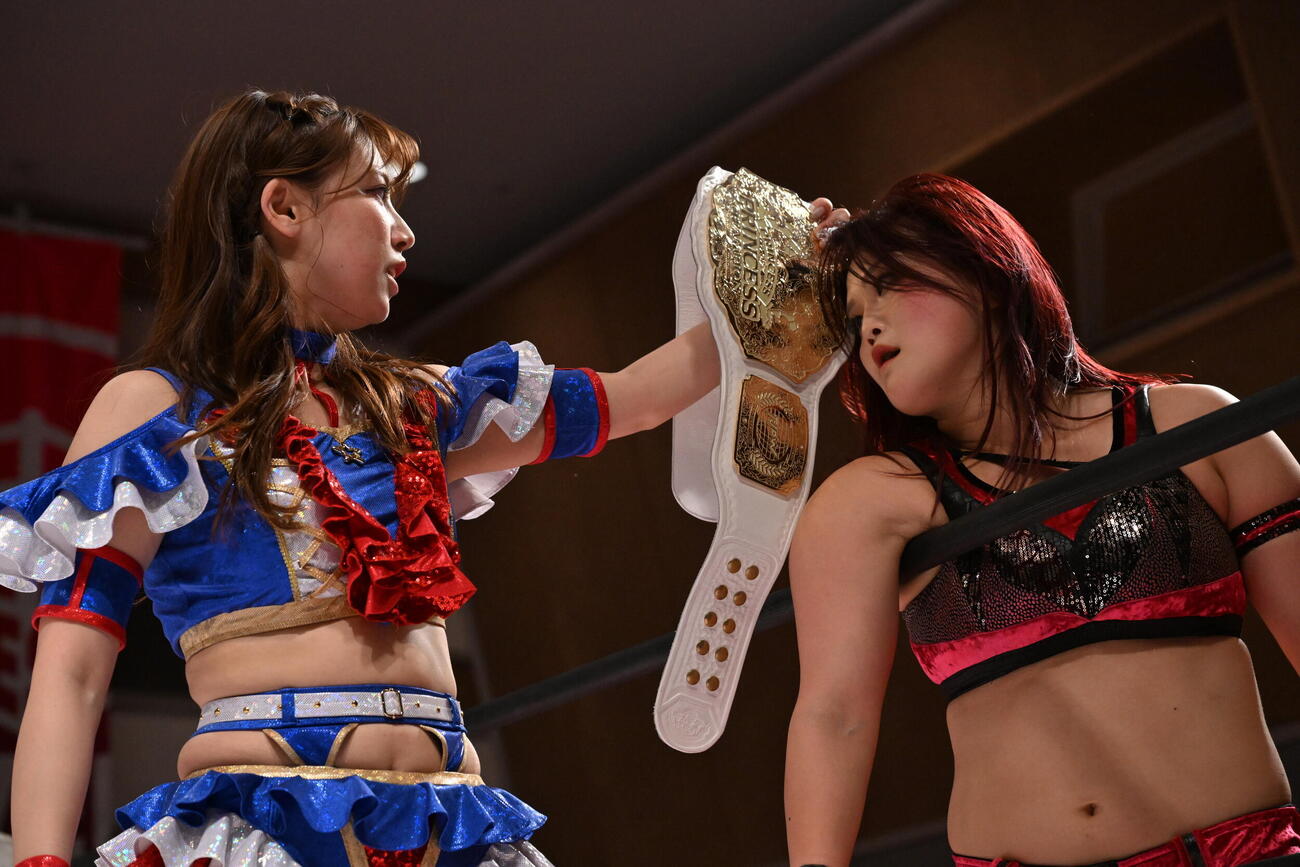 山下実優（右）の目の前でベルトをアピールする荒井優希（C）東京女子プロレス