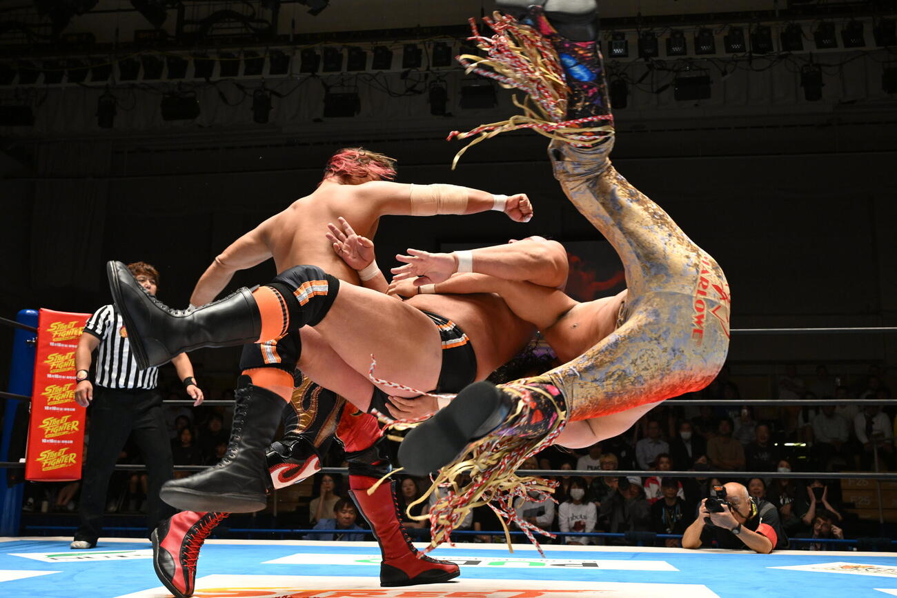 鷹木（左）のパンピングボンバーと辻（右）のジーンブラスターがジャクソン（中央）にたたきこまれた（C）新日本プロレス