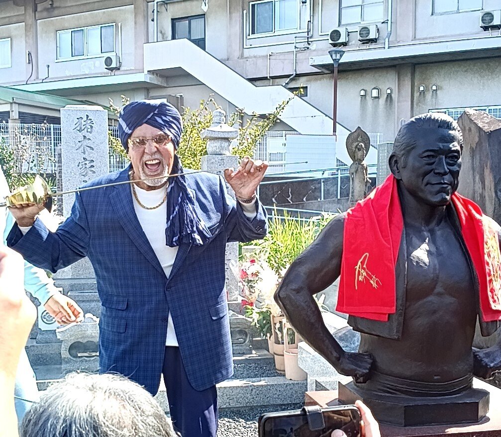故アントニオ猪木さんの墓前でサーベルをくわえるタイガー・ジェット・シン氏