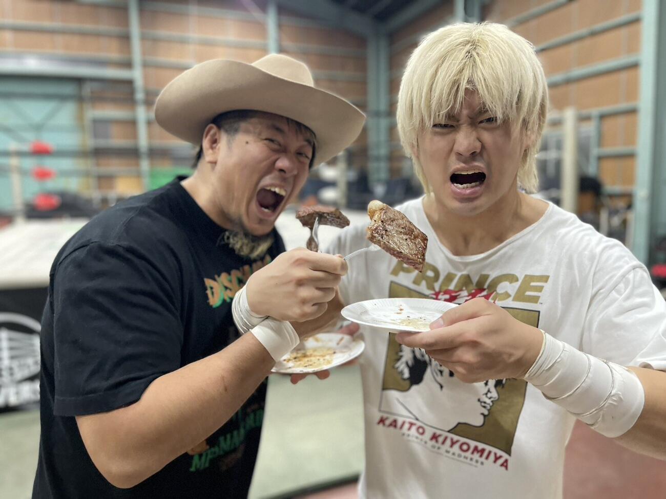 ステーキにかぶりつくYoshiki Inamura（左）と清宮海斗（C）プロレスリング・ノア