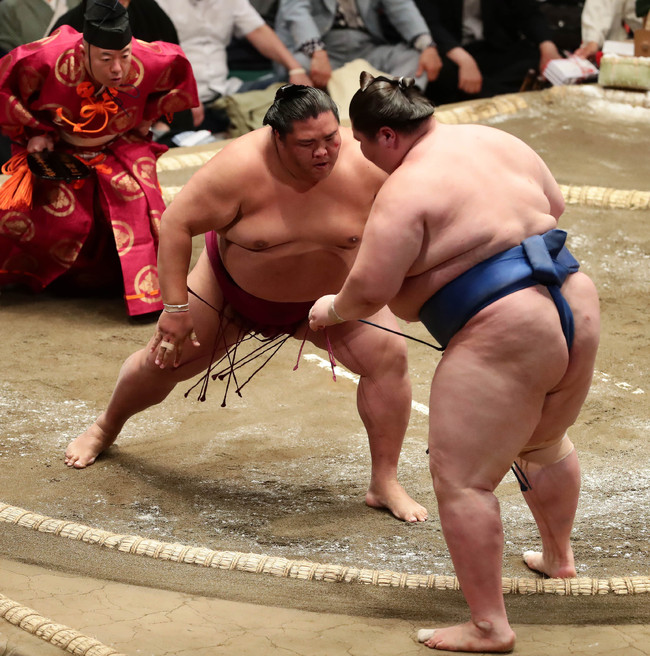 逸ノ城を押し出しで破った御嶽海（左）