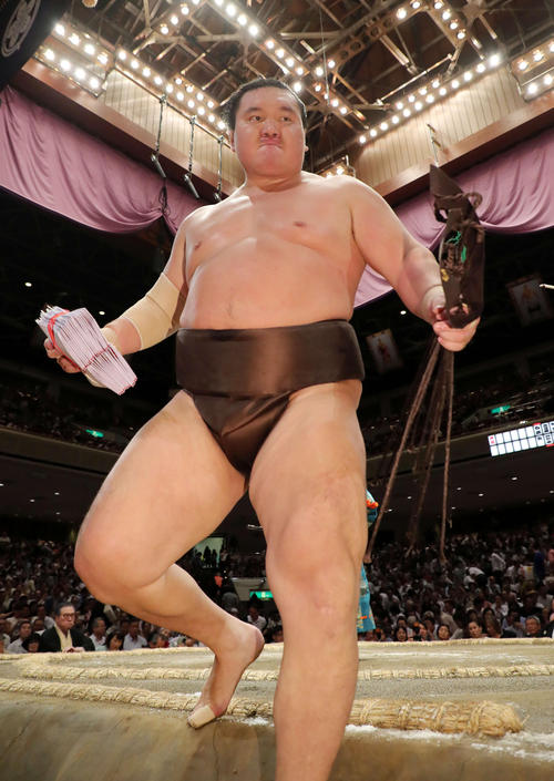 懸賞金の束を手に土俵を引き揚げる白鵬（撮影・鈴木正人）