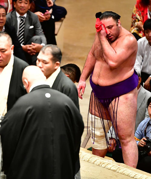 流血した顔面をタオルで押さえながら審判団の協議を待つ栃ノ心(撮影・小沢裕)