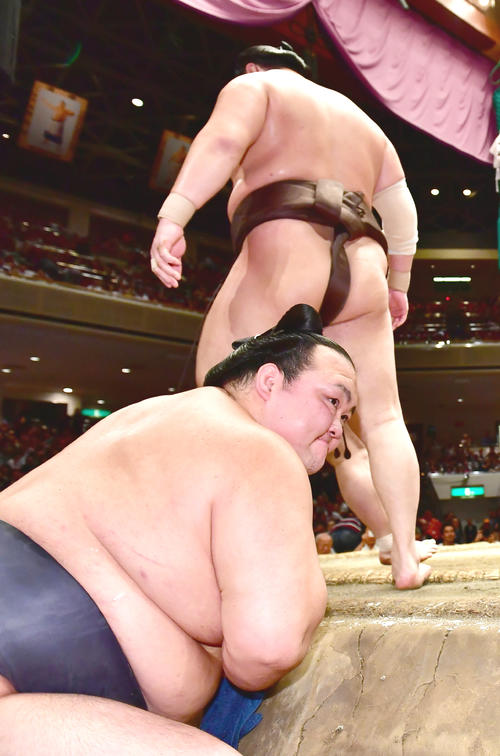 稀勢の里（左）は土俵下で白鵬の優勝を見届け花道へ引き揚げる（撮影・小沢裕）