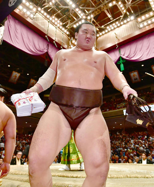 優勝を決めた白鵬は懸賞の束を手に土俵を引き揚げる（撮影・小沢裕）