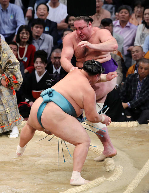 栃ノ心(後方)を押し出しで破る玉鷲(撮影・鈴木正人)