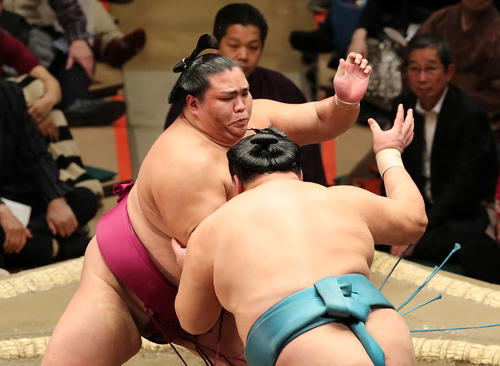 玉鷲(手前)を激しく攻める御嶽海(撮影・鈴木正人)