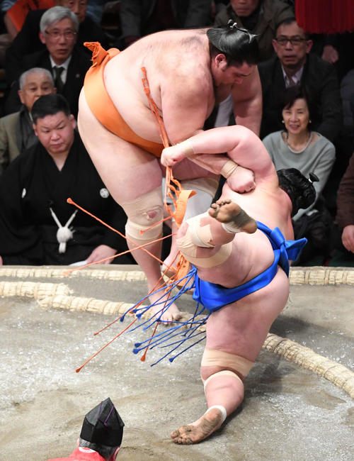 琴奨菊（下）をすくい投げで破る魁聖（撮影・山崎安昭）