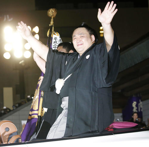 大勢のファンが祝福の声援を送る中、笑顔で沿道に手を振る玉鷲（撮影・河田真司）