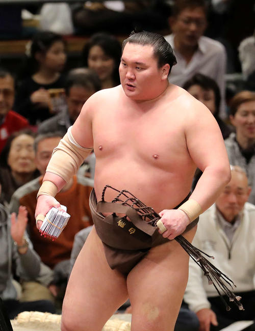 懸賞金の束を手に土俵を引き揚げる白鵬（撮影・鈴木正人）