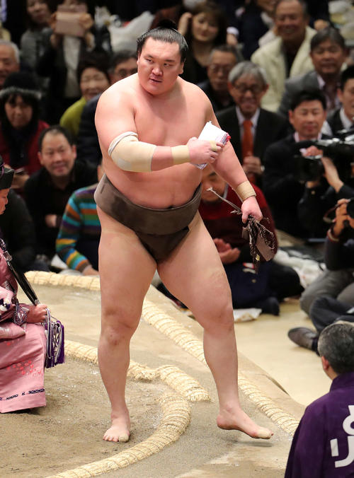 懸賞金の束を手に土俵を引き揚げる白鵬(撮影・鈴木正人)