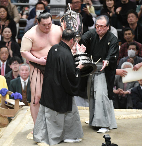 白鵬(左)は助けを借りて賜杯を受け取る(撮影・渦原淳)